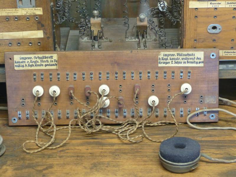 Vintage wooden switchboard with multiple buttons and wires.
