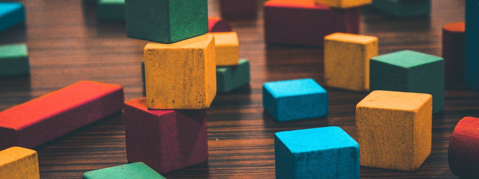 Assorted vibrant blocks in various shapes and sizes on a wooden table.